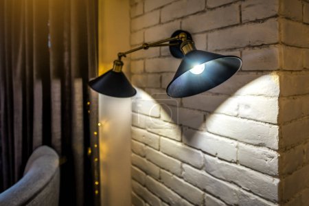Foto de Antiguo y vintage poste de lámpara negro colgando en la pared de ladrillo para la iluminación romántica. Estilo Loft. - Imagen libre de derechos
