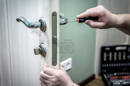 Téléchargez les photos : Serrurier professionnel réparer ou installer la serrure de porte dans la maison - en image libre de droit