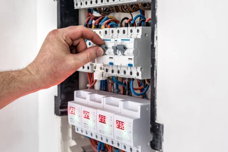 Téléchargez les photos : Réparer ou éteindre la tension du standard avec des interrupteurs automatiques. Fond électrique - en image libre de droit