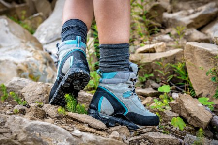 Téléchargez les photos : Jambes en bottes de randonnée professionnelles sur sentier rocheux - en image libre de droit