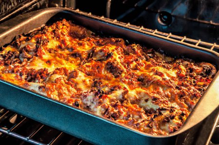 Photo for Cooked hot delicious lasagna in the oven. Food and drink theme - Royalty Free Image