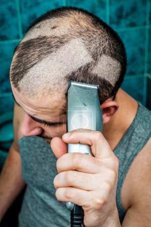 Photo for Crazy man shaving himself with an electric razor clipper - Royalty Free Image