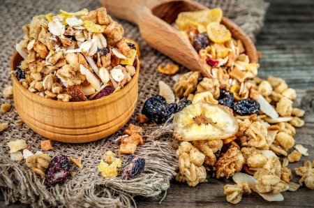 Photo for Homemade granola with dry fruits for breakfast in wooden bowl and scoop - Royalty Free Image