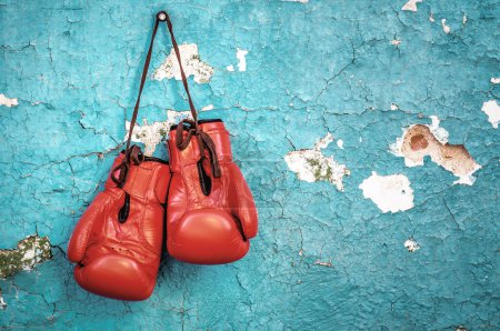 Photo for New professional red boxing gloves on the nail on old cracked wall - Royalty Free Image