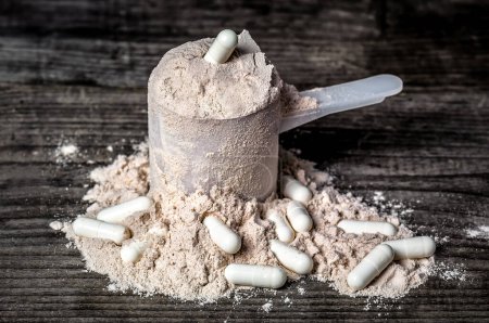 Photo for Protein scoop and bcaa pills on wooden background - Royalty Free Image