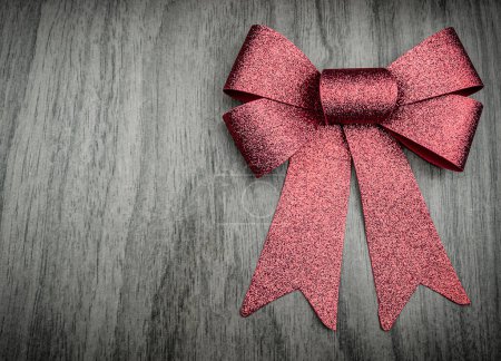 Photo for Red shining bow ribbon on wooden background. Wallpaper - Royalty Free Image