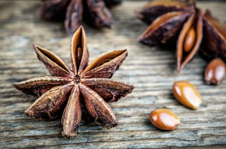 Photo for Scented star anise and seeds on wooden background - Royalty Free Image