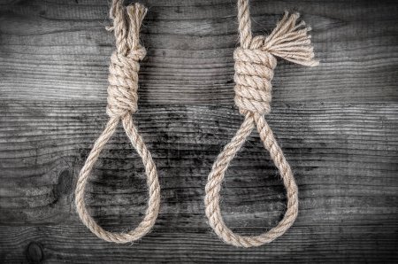 Deux cordes avec noeud pour suicide sur fond monochrome en bois