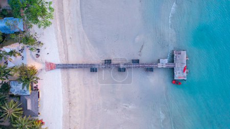 Photo for A pier bridge stretching over a sandy beach into the sea, Koh Mak, Trat Province, Thailand. - Royalty Free Image