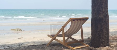 Téléchargez les photos : Chaises de plage au bord de la mer sous les pins - en image libre de droit