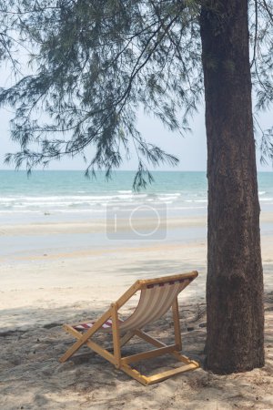 Foto de Sillas de playa a orillas del mar bajo pinos - Imagen libre de derechos