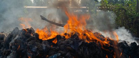Foto de El fuego está ardiendo en una pila de basura, causando PM.2.5. - Imagen libre de derechos