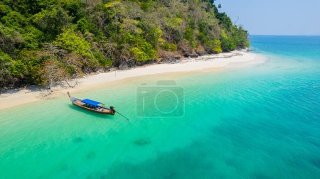 Sandy beach with beautiful sea water and long-tail boats on the pristine white beach of Bat Island in the Andaman Sea of Ranong Province, southern Thailand, Asia