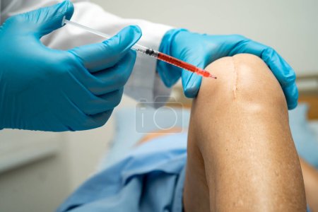 Foto de Médico asiático inyectar plasma rico en plaquetas de ácido hialurónico en la rodilla de la mujer mayor para caminar sin dolor. - Imagen libre de derechos