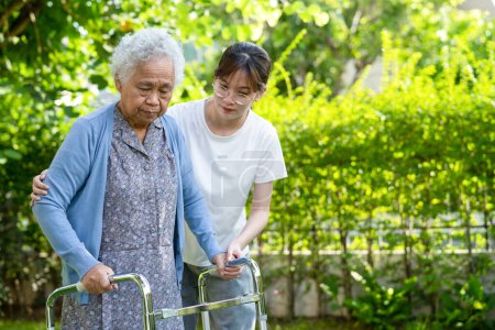 Photo for Caregiver help and care Asian senior or elderly old lady woman use walker with strong health while walking at park in happy fresh holiday. - Royalty Free Image