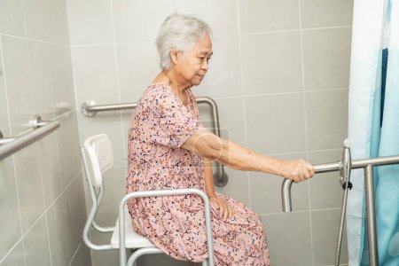 Téléchargez les photos : Asiatique senior ou vieille dame femme patient utilisation toilettes salle de bain poignée sécurité dans la salle d'hôpital de soins infirmiers, concept médical fort sain. - en image libre de droit
