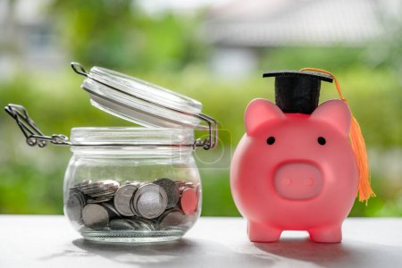 Photo for Save money coins in grass jar with piggy bank and graduation cap, Business finance education concept. - Royalty Free Image