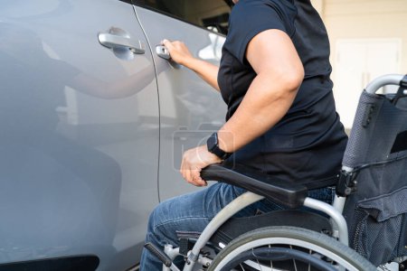 Foto de Mujer asiática plegable y levantar la silla de ruedas en su coche. Concepto de accesibilidad. - Imagen libre de derechos