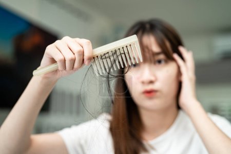 Téléchargez les photos : Asian woman have problem with long hair loss attach to comb brush. - en image libre de droit
