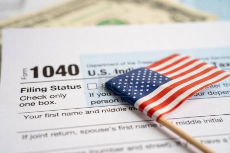 Foto de Formulario de declaración de impuestos 1040 con bandera de Estados Unidos y billete en dólares, EE.UU. Ingresos individuales. - Imagen libre de derechos