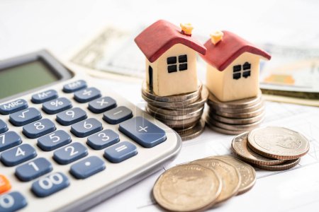 Haus auf Stapelmünzen mit Taschenrechner, Hypothekenkredit Finanzierungskonzept.