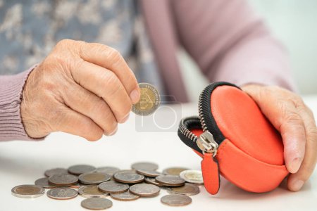 Photo for Asian senior or elderly old lady woman holding counting coin money in purse. Poverty, saving problem in retirement. - Royalty Free Image