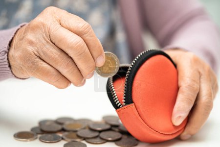 Photo for Asian senior woman holding counting coin money in purse. Poverty, saving problem in retirement. - Royalty Free Image