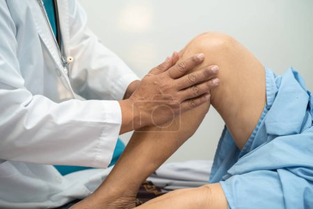 Médecin physiothérapeute asiatique examinant, massant et traitant le genou et la jambe d'un patient âgé dans une clinique médicale orthopédiste infirmière hôpital.