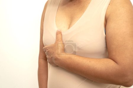 Téléchargez les photos : Femme asiatique patient vérifier et s'inquiéter de son sein, auto-examen du sein ou BES, symbole de la Journée mondiale du cancer du sein. - en image libre de droit