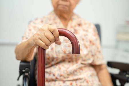 Téléchargez les photos : Asiatique personne âgée handicapée femme tenant bâton de marche, canne à bois, poignée ronde, aide à la marche pour aider à marcher. - en image libre de droit
