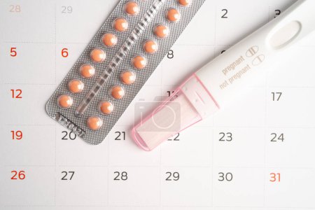 Téléchargez les photos : Test de grossesse et pilules contraceptives sur calendrier, contraception santé et médecine. - en image libre de droit
