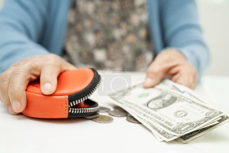 Photo for Asian senior woman holding counting coin money and Euro bnaknotes in purse. Poverty, saving problem in retirement. - Royalty Free Image