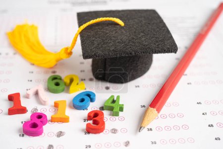 Photo for Graduation gap hat and pencil on answer sheet paper, Education study testing learning teach concept. - Royalty Free Image