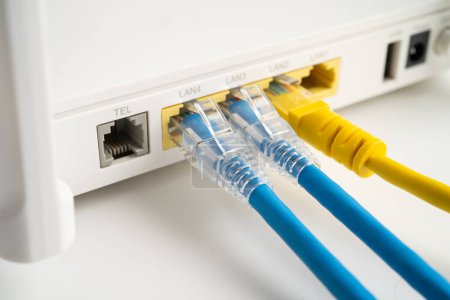 Téléchargez les photos : Câble Ethernet avec routeur sans fil connecté au réseau Internet du fournisseur de services Internet. - en image libre de droit