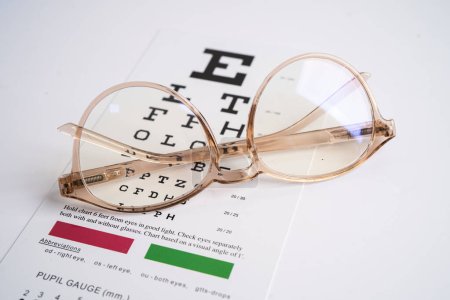 Glasses on eye testing exam chart to check eyesight accuracy of reading.
