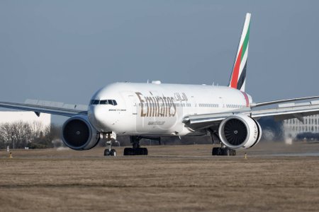 Foto de PRAGA - 27 de diciembre de 2023: Emirates Boeing 777-31H (ER) REG: A6-EPU at Vaclav Havel Airport Prague. Emirates es la aerolínea más grande y una de las dos aerolíneas con bandera de los Emiratos Árabes Unidos.. - Imagen libre de derechos