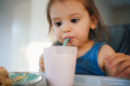 Photo for The girl drank water, after she was thirsty after eating. Kid has lunch,meal,healthy food - Royalty Free Image