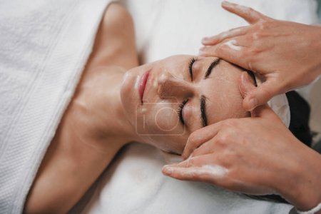 Foto de Mujer en el salón de spa recibiendo tratamiento de masaje facial. Tratamiento facial femenino. Cuidado de la piel. Cuidado corporal. - Imagen libre de derechos