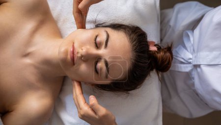 Kosmetologen geben einer Frau im Büro eine Gesichts- und Nackenmassage zur Elastizität der Haut. Entspannte Kundin. Schönheitsbehandlung im Gesicht, Körperpflege
