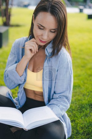 Foto de Mujer joven leyendo un libro en el parque al aire libre. Concepto de fe, espiritualidad. Paz, esperanza - Imagen libre de derechos