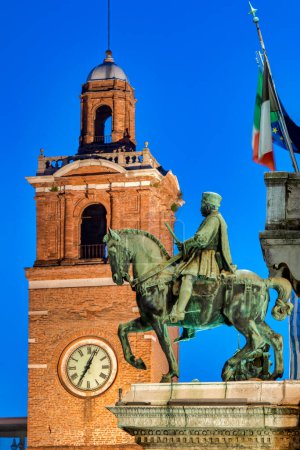 Photo for Equestrian statue of Niccolo III d'Este with the Clock Tower on the background, Ferrara Italy - Royalty Free Image