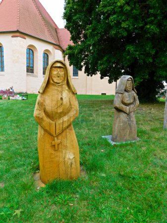 Foto de Boitzenburg, distrito de Brandeburgo de Uckermark / Alemania - 27 de agosto de 2023: Figuras de madera frente a la iglesia parroquial de San Marien en las montañas - Imagen libre de derechos