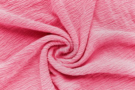 Foto de Tejido rosa suave con textura arrugada retorcida en espiral. Fondo abstracto en color de moda del año 2023 Viva Magenta. Concepto de tendencias de diseño de moda y ropa - Imagen libre de derechos
