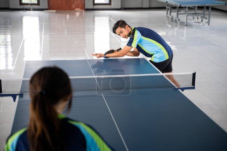 Photo for Asian athlete ready to serve during a ping pong match at the ping pong table - Royalty Free Image
