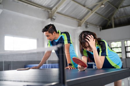 Photo for Asian ping pong doubles players get frustrated when they lose a ping pong match - Royalty Free Image