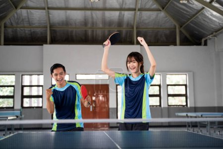 Photo for Asian ping pong doubles players excited when they score at the ping pong table - Royalty Free Image