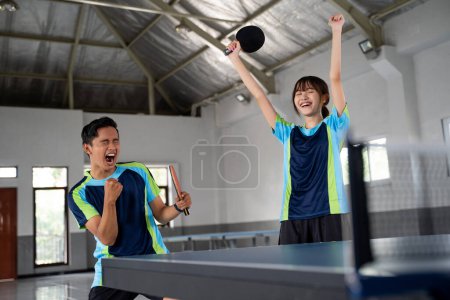 Photo for Male and female ping pong doubles players excited during a ping pong match - Royalty Free Image