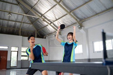 Photo for Male and female ping pong players happy to score in ping pong match - Royalty Free Image