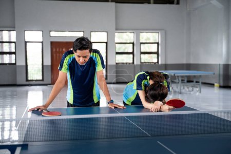 Photo for Asian male and female ping pong players get frustrated when they lose a ping pong match - Royalty Free Image