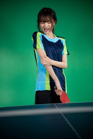 Photo for Female ping pong player injured arm muscle during ping pong match - Royalty Free Image